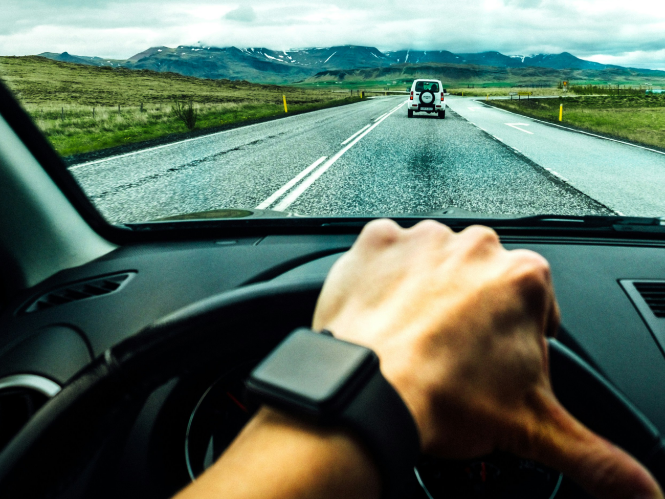 A driver wearing a smartwatch while driving in adequate distance to another car